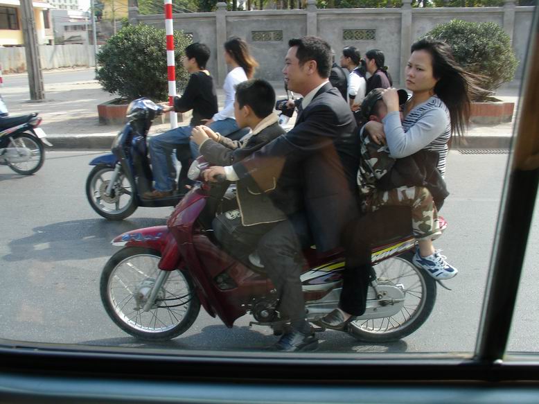 Vietnam nas sokoval hned nekolikrat. Jizda na motocyklu ve ctyrech je normalni. Lide jezdi klidne v obleku a samozrejme bez helmy.